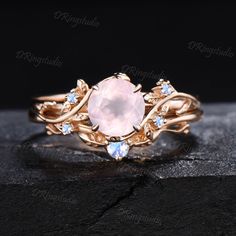 an oval pink stone surrounded by blue topazte and white diamonds in a gold ring