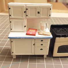 a toy kitchen with an oven, stove and counter top on the floor in front of it