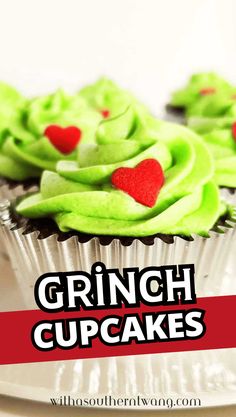 cupcakes with green frosting and red hearts on them are sitting on a plate