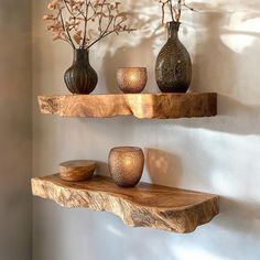 three wooden shelves with vases and candles on them