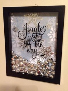 a black frame hanging on the wall above a toilet with silver and white snowflakes