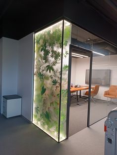 an office with glass walls and plants on the wall