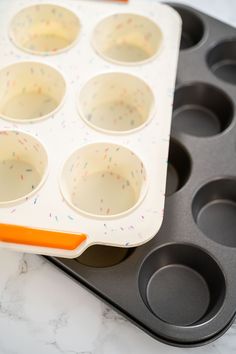 a muffin tray filled with cupcake batters on top of a marble counter