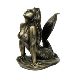 a bronze statue of a mermaid sitting on top of a rock with her tail curled up