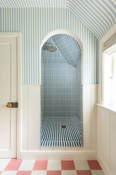 a bathroom with blue and white walls, checkered flooring and a shower stall