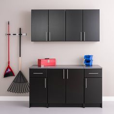 a garage with black cabinets and tools hanging on the wall