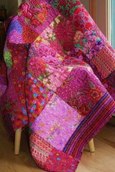 a patchwork blanket sitting on top of a wooden chair