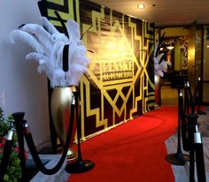 a red carpeted hallway with white and black decorations on the wall next to it