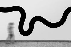 a black and white photo of a person riding a skateboard in front of a wall