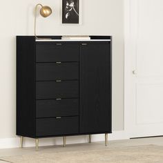 a black cabinet with gold handles in a white living room next to a painting on the wall