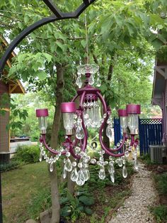 a pink chandelier hanging from a tree