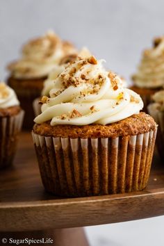 cupcakes with white frosting and walnut sprinkles on a wooden tray