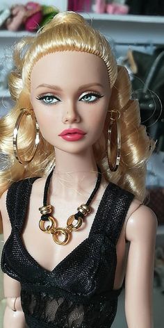 a barbie doll with blonde hair and big hoop earrings on her head wearing a black dress