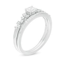 a white gold engagement ring with three stones on the side and two rows of diamonds at the top