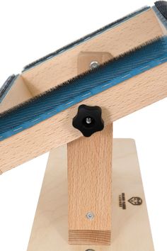 a close up of a wooden object with a blue handle and black knob on it