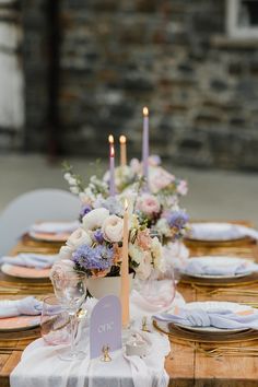 the table is set with flowers and candles