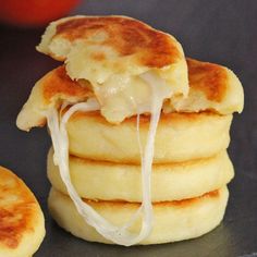 a stack of pancakes sitting on top of a metal pan covered in cheese and sauce