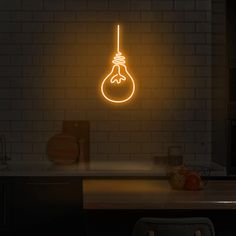 a neon light bulb hanging from the side of a kitchen wall