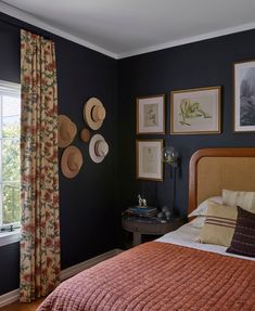 a bed sitting in a bedroom next to a window with pictures on the wall above it