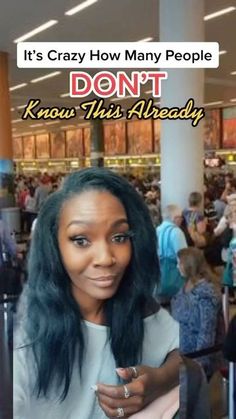 a woman with long black hair standing in an airport