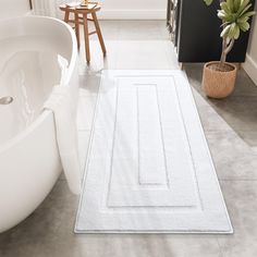 a bathroom with a bathtub and rug on the floor