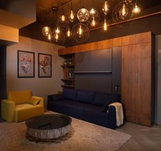 a living room filled with furniture and lots of light bulbs hanging from the ceiling above