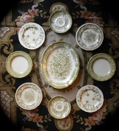 a table topped with lots of plates and bowls on top of a floral covered table cloth