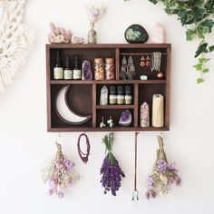 a wooden shelf filled with lots of different types of flowers and jewelry hanging from it's sides