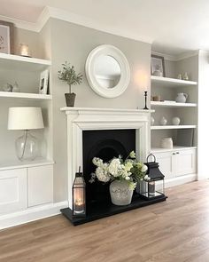 a living room filled with furniture and a fire place in front of a white fireplace