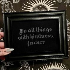 someone is holding up a cross - stitch frame with the words go all things with kindness