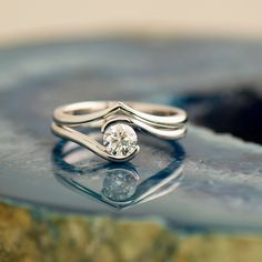 a close up view of a diamond ring on a rock