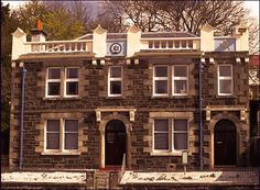 an old brick building with white trim on the front and side windows is shown in this image