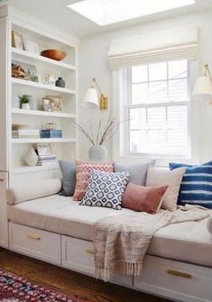 a living room filled with lots of furniture and bookshelves next to a window