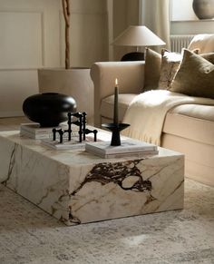 a marble coffee table with candles on it