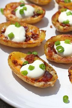 small appetizers on a white plate with green onions and cream cheese toppings