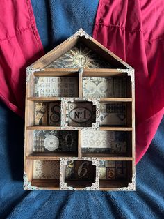 a house made out of money sitting on top of a blue cloth covered bedding