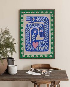 a wooden table topped with a potted plant next to a painting