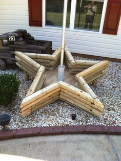 a star shaped wooden structure sitting on top of gravel