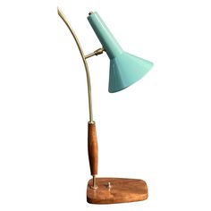 a desk lamp with a wooden base and a light blue shade on the top, against a white background