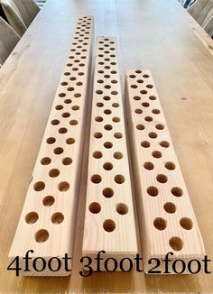 three wooden pegs sitting on top of a table next to each other with holes in them