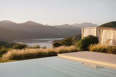 an outdoor swimming pool with mountains in the background