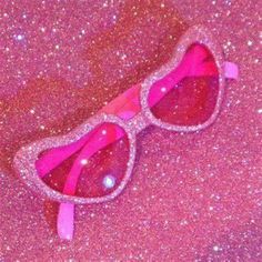 a pair of pink sunglasses with glitter on them