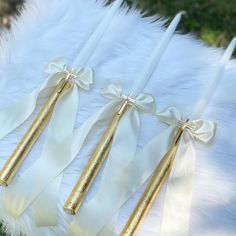 white and gold wedding garters with bows on them, sitting on a fur rug