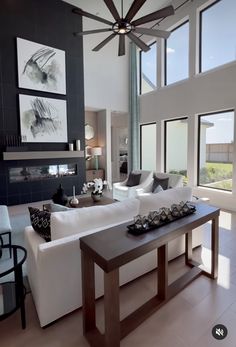 a living room with white furniture and large windows