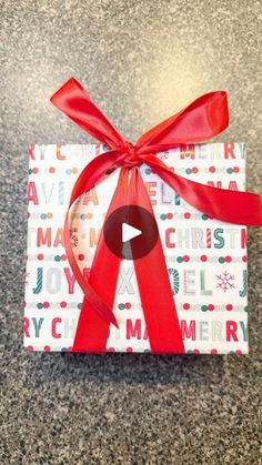 a gift wrapped in wrapping paper with a red ribbon