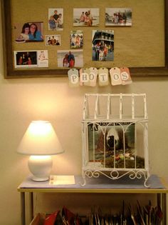 a white birdcage sitting on top of a table next to a lamp