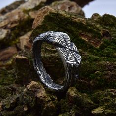 a silver ring sitting on top of rocks