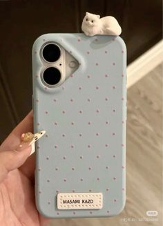 a person holding up a phone case with a cat on it's back cover