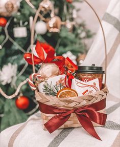 a basket filled with food sitting on top of a table next to a christmas tree