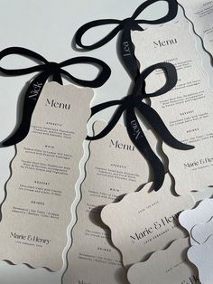 two black and white menus with ribbon tied to them